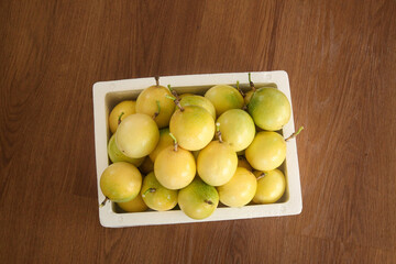 Fresh Golden Passion Fruit in White Basket on Wood Table - Tropical Fruits Ready to Eat