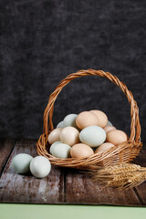 Fresh Free-Range Eggs in Wicker Basket - Colorful Farm Eggs on Rustic Wood Table