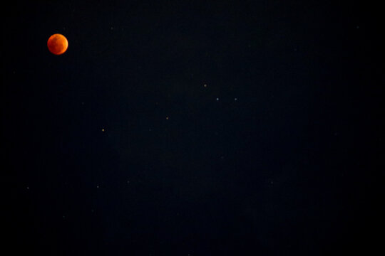 A beautiful rare blood moon on a dark night sky - Powered by Adobe