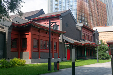 Fototapeta premium traditional chinese house against the background of a modern office building