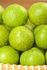 Fresh Green Plums with Water Droplets in Wicker Basket - Organic Fruit Close-Up