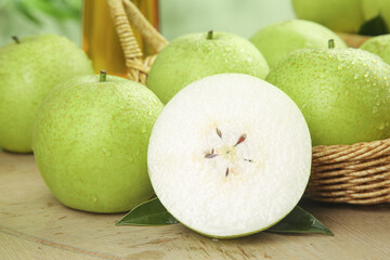 Fresh Green Pears and Apple Crown Jade Variety in Wicker Basket on Wooden Background