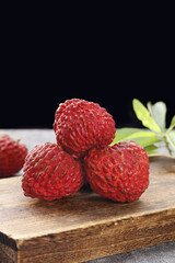 Fresh Red Lychee Fruits on Wooden Board - Exotic Tropical Asian Fruit Ready for First Harvest