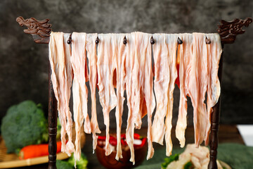 Fresh Handmade Noodles Drying on Traditional Wooden Rack with Fresh Vegetables