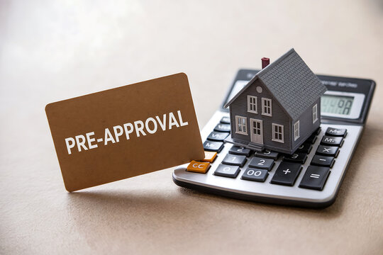 Miniature house on calculator with pre approval card home finance