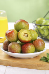 Fresh Ripe Plums with Red Green Skin on White Plate Showing Juicy Flesh and Pit Healthy Fruit Snack