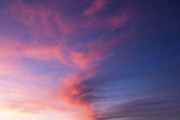 Fototapeta premium sky at sunset with pink, orange, purple, blue, and turquoise clouds and violet hues
