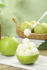 Fresh Green Pear Melon Balls in Natural Pear Bowl with Wicker Basket on Wooden Table