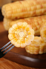 Baby Sweet Corn Cross-Section on Fork with Wooden Background - Fresh Vegetable Food Photography