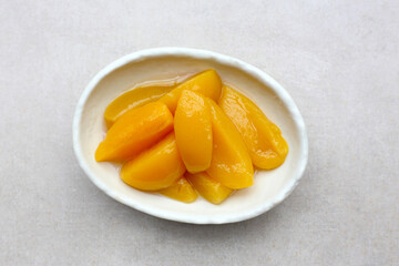 Sliced peaches in syrup served in a bowl