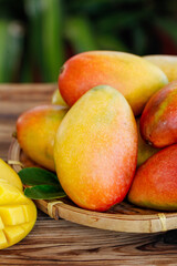 Fresh Hainan Guifei Mangoes in Bamboo Basket Display - Colorful Tropical Fruit
