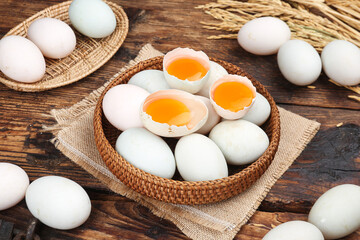 Fresh Farm Eggs with Orange Yolks in Wicker Baskets on Rustic Wood Table