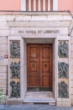 The door decorated with black sculptures of the Casa del Mutilato in Massa, Italy