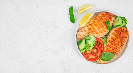 Grilled chicken breasts with fresh vegetables on white background. Long banner format. top view. copy space