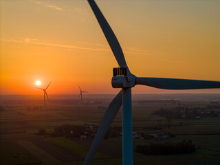 A wind turbine at sunrise, bathed in warm sunlight. Wind energy generates clean, renewable, and emission-free power. © Robert