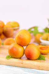 Fresh Ripe Apricots on Wooden Board with Mint Leaves in Light Kitchen Setting