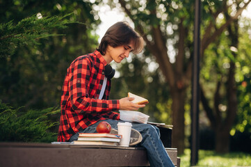 Fototapeta premium Time for lunch, with food. Male student is in the public park outdoors
