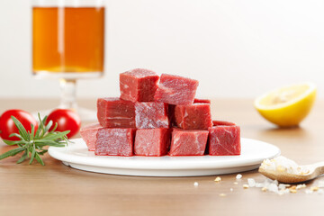 Fresh Raw Diced Beef Cubes with Herbs and Vegetables on Kitchen Counter Ready for Cooking