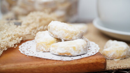 Homemade Putri Salju cookies coated in powdered sugar, and with hot black coffee. Perfect for festive food promotions and design assets