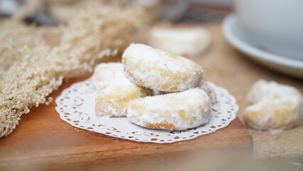 Homemade Putri Salju cookies coated in powdered sugar, and with hot black coffee. Perfect for festive food promotions and design assets