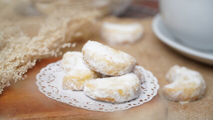 Homemade Putri Salju cookies coated in powdered sugar, and with hot black coffee. Perfect for festive food promotions and design assets