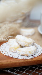 Homemade Putri Salju cookies coated in powdered sugar, and with hot black coffee. Perfect for festive food promotions and design assets