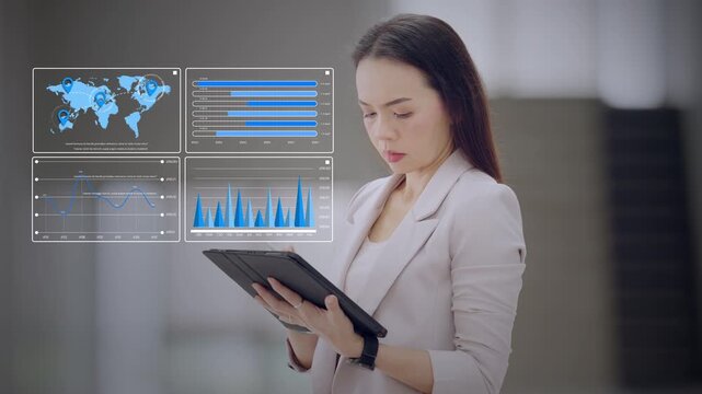Asian businesswoman using tablet to review a virtual dashboard with global map, charts, and monthly data. Concept of business analytics, data strategy, and digital performance.