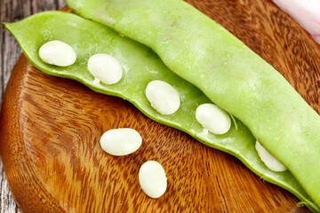 Fresh Lima Beans in Green Pods on Wooden Board - Healthy Legumes and Vegetables