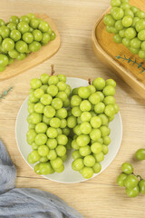 Fresh Green Grapes in Wooden Bowls and White Plate on Natural Wood Background