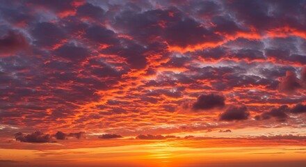 Obraz premium Fiery Sunset Over the Horizon with Dramatic Clouds.