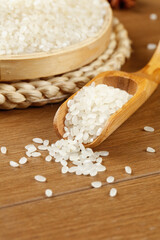 Fresh White Long Grain Rice in Wooden Spoon with Traditional Bamboo Steamer Asian Cooking Ingredients