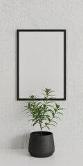 Fototapeta premium Black frame mockup with plant on white wall, perfect for artwork display