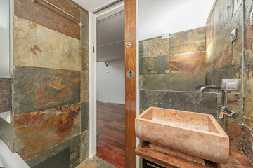 Minimalist bathroom with an oval porcelain sink, stainless steel faucets, and a frameless glass shower enclosure
