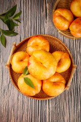 Fresh Shandong Yimeng Mountain Peaches in Wicker Baskets on Rustic Wood Background