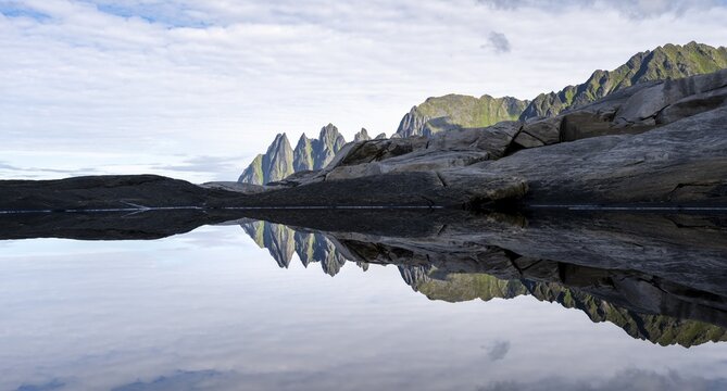 Reflection in a tidal pool, rocky coast of Tungeneset, Devil's Teeth, Okshornan, Ersfjorden, Senja Island, Troms, Norway