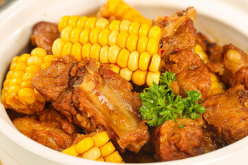 Hearty Pork Ribs Stew with Fresh Corn and Herbs in White Bowl