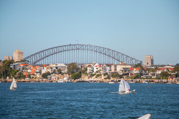 Naklejka premium Sydney Harbour Bridge with sailing boats and waterfront houses on a sunny day