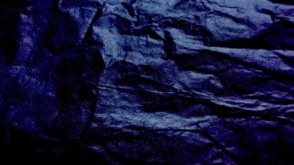 dark indigo crumpled paper texture with glossy folds and deep shadows creating moody abstract background for wallpaper or banner design