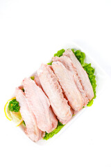 Fresh Raw Duck Wings with Lettuce and Lemon Garnish on White Background for Gourmet Cooking