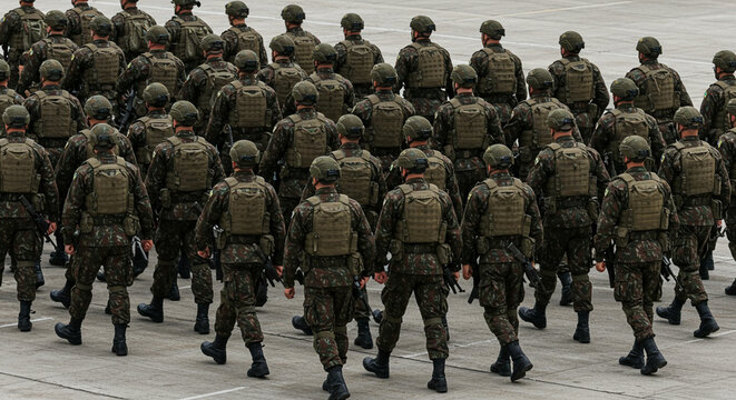 Brazilian army soldiers in formation and marching, facing backwards, equipped for battle. IA