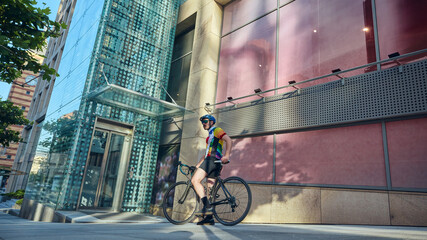 Cyclist resting with road bike near glass building in urban environment. Concept of active...