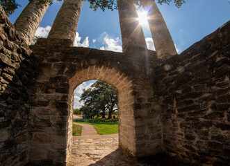 sun shining through stone columns 