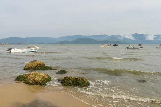 Florianopolis, Brazil - September 4th 2025: Boats in Caieira da Barra do Sul (fishermen village) and Serra (mountain range) in the background