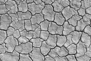 Close-up of dry, cracked soil surface,Close-up image showcasing the intricate patterns of a dry, cracked sand surface, highlighting the natural abstract formations and textures.