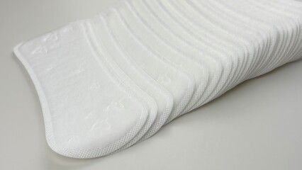 Women's sanitary pads on white background, top view. Feminine hygiene and menstruation product. Daily pad for period care, women's health, advertising, article or banner concept