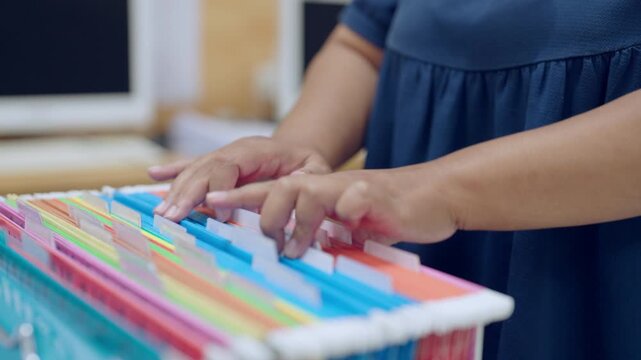 Efficient document filing system using color-coded hanging folders, representing organized workflow and office operations.