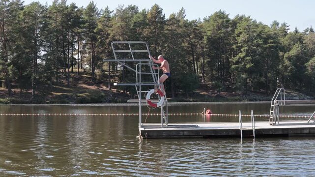 Stockholm, Sweden A man jumps off a diving board into Lake Malaren in summer. 