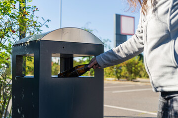 Eine Pfandflasche wird aus einem Mülleimer geholt