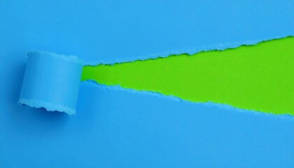 A close-up shot revealing a creative process. Blue paper is torn to expose a vibrant green background. The torn edge adds texture and depth