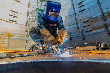 Welding male worker metal is part of machinery plate roof tank beam construction